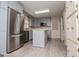 Kitchen with island, stainless steel refrigerator, and white and blue cabinetry and wood-look flooring at 65 Pine Haven Ct, Carrollton, GA 30116