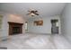 Spacious living room with fireplace, neutral carpet, ceiling fan, and view into the kitchen at 65 Pine Haven Ct, Carrollton, GA 30116