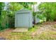 Outdoor metal storage shed with a large door and chain link fence at 65 Pine Haven Ct, Carrollton, GA 30116