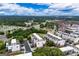 Aerial view of the modern townhome community surrounded by green spaces and a distant cityscape at 2118 Iverson Se Dr, Smyrna, GA 30080