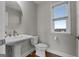 Stylish half bathroom with pedestal sink, hardwood floors, and window at 2118 Iverson Se Dr, Smyrna, GA 30080