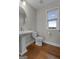 Stylish half bathroom with pedestal sink, hardwood floors, and window at 2118 Iverson Se Dr, Smyrna, GA 30080