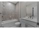 Bathroom featuring tiled walls, a shower-tub combo, and a vanity with a sink and mirror at 2118 Iverson Se Dr, Smyrna, GA 30080