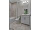 Bathroom with tile flooring, tub-shower, and white vanity with decorative lighting and mirror at 2118 Iverson Se Dr, Smyrna, GA 30080