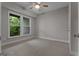 An empty bedroom featuring neutral walls and carpet, a window with a view, and a ceiling fan at 2118 Iverson Se Dr, Smyrna, GA 30080