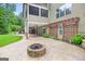 Backyard patio with fire pit, pergola, and screened-in porch, surrounded by lush greenery at 52 Olivia Ct, Palmetto, GA 30268
