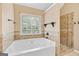 Bathroom showcasing a tub and glass shower, enhancing the room's serene ambiance with natural light at 52 Olivia Ct, Palmetto, GA 30268