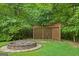 Cozy backyard fire pit area with stone surround and wooded backdrop at 52 Olivia Ct, Palmetto, GA 30268
