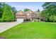 Well-maintained brick home boasts lush green lawn, mature landscaping, and inviting front porch at 52 Olivia Ct, Palmetto, GA 30268