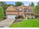 Charming two-story brick home with a well-manicured lawn, attached garage, and inviting front porch at 52 Olivia Ct, Palmetto, GA 30268