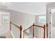 Hallway with wood railings and carpet flooring that leads to bedrooms at 52 Olivia Ct, Palmetto, GA 30268