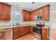 Kitchen featuring granite countertops, wooden cabinets, stainless steel appliances, and hardwood floors at 52 Olivia Ct, Palmetto, GA 30268