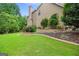 Well-maintained backyard landscaping with stone accents and green lawn at 52 Olivia Ct, Palmetto, GA 30268
