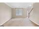 Living room with carpet flooring, large window, and view of the stairway at 52 Olivia Ct, Palmetto, GA 30268