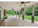 Covered stone patio features ceiling fans, stone pillars, fire pit, and wooded backyard at 52 Olivia Ct, Palmetto, GA 30268