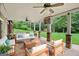Covered stone patio features ceiling fans, TV, stone pillars, and outdoor seating area at 52 Olivia Ct, Palmetto, GA 30268