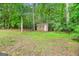 Backyard featuring a shed, set among mature trees and natural surroundings at 52 Olivia Ct, Palmetto, GA 30268