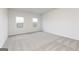 A bright bedroom featuring two windows, neutral walls, and plush carpet flooring at 280 Oliver Dr, Locust Grove, GA 30248