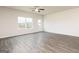 Bright, open-concept living room with wood floors, fan, and a view of the backyard at 280 Oliver Dr, Locust Grove, GA 30248