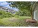 Overgrown backyard view showcasing a multi-Gathering building, mature trees, and patio area perfect for outdoor gatherings at 734 Meadowlark Dr, Villa Rica, GA 30180
