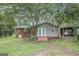 Backyard of a home with brick, siding, dual french doors, small patio, and some privacy landscaping at 734 Meadowlark Dr, Villa Rica, GA 30180