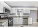 Close up of kitchen with stainless steel appliances, white cabinets, and ceramic tile floors at 734 Meadowlark Dr, Villa Rica, GA 30180