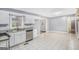 Well-lit kitchen featuring white cabinets, stainless steel dishwasher, and ceramic tile flooring at 734 Meadowlark Dr, Villa Rica, GA 30180