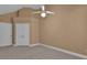 This bedroom features neutral carpeting, a ceiling fan and a closet with paneled doors at 111 Kenton Pl, Peachtree City, GA 30269