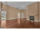 Open-concept living room featuring hardwood floors and a traditional fireplace with views to the exterior at 111 Kenton Pl, Peachtree City, GA 30269