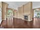 Spacious living room featuring dark hardwood floors, a fireplace, and many large windows at 111 Kenton Pl, Peachtree City, GA 30269