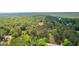 Aerial view showcasing a home surrounded by dense woods and a lush green landscape at 8129 S Giles Rd, Douglasville, GA 30135