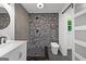 Modern bathroom featuring an open walk-in shower with pebble flooring and a floating toilet at 8129 S Giles Rd, Douglasville, GA 30135