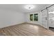 Bright bedroom featuring hardwood floors, a ceiling fan, and closet with sliding barn door at 8129 S Giles Rd, Douglasville, GA 30135