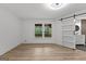 Bright bedroom featuring hardwood floors, a ceiling fan, and closet with sliding barn door at 8129 S Giles Rd, Douglasville, GA 30135