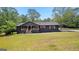 Charming black home with a covered front porch and natural wood accents surrounded by lush greenery at 8129 S Giles Rd, Douglasville, GA 30135