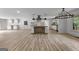 Bright kitchen with white cabinets, a center island with butcher block countertop, and modern lighting at 8129 S Giles Rd, Douglasville, GA 30135