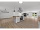 Open living room featuring a large island, wood burning fireplace and hardwood style floors at 8129 S Giles Rd, Douglasville, GA 30135