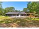 Rear exterior view of home highlighting a new patio and landscaping in the sprawling backyard at 8129 S Giles Rd, Douglasville, GA 30135