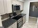 Updated kitchen features stainless steel appliances, granite counters, and gray cabinets at 5147 Roswell Rd # 47, Atlanta, GA 30342