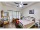 Spacious bedroom featuring hardwood floors, a display cabinet, and a black metal bed frame beneath a tray ceiling at 129 Onyx Ct, Carrollton, GA 30116