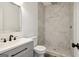 Modern bathroom featuring marble-style tile shower, gray vanity with black hardware, and sleek fixtures at 4186 Matisse Ln, Fairburn, GA 30213