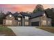 Stunning two-story home boasts a stone and brick facade, a sprawling driveway, and a lush, landscaped lawn at 4186 Matisse Ln, Fairburn, GA 30213