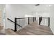 Bright hallway featuring laminate floors, contemporary railing, and natural light, creating an inviting atmosphere at 4186 Matisse Ln, Fairburn, GA 30213