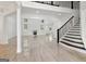 Spacious living room with modern stairs, fireplace, tiled floors, and large windows provides a luxurious atmosphere at 4186 Matisse Ln, Fairburn, GA 30213