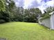 Lush backyard featuring a well-maintained lawn and mature trees at 150 Willow Shoals Dr, Covington, GA 30016