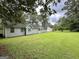 Home exterior overlooking a large, green backyard with mature trees at 150 Willow Shoals Dr, Covington, GA 30016
