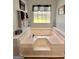 A large soaking tub with jets surrounded by tile in a bathroom at 150 Willow Shoals Dr, Covington, GA 30016
