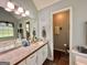 Bathroom features tub, white cabinets and drawers, and neutral colored walls at 150 Willow Shoals Dr, Covington, GA 30016