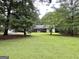 One-story home with a well-manicured lawn and mature trees at 150 Willow Shoals Dr, Covington, GA 30016
