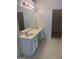 Bathroom featuring dual sinks with white cabinets, a large mirror, vinyl flooring, and a nearby walk-in closet at 1925 Cedar Walk Ln, Conley, GA 30288